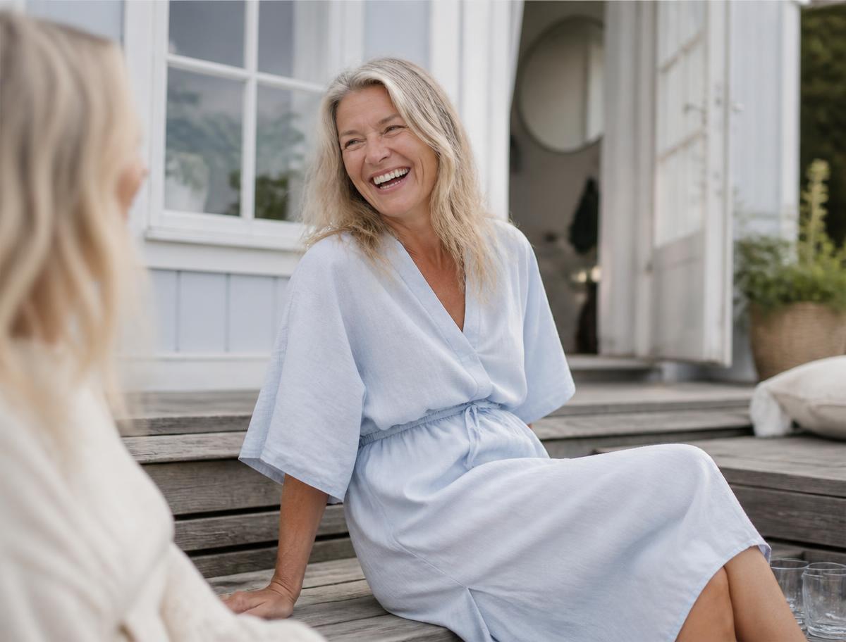 Kvinna som skrattar med en vän en sommardag